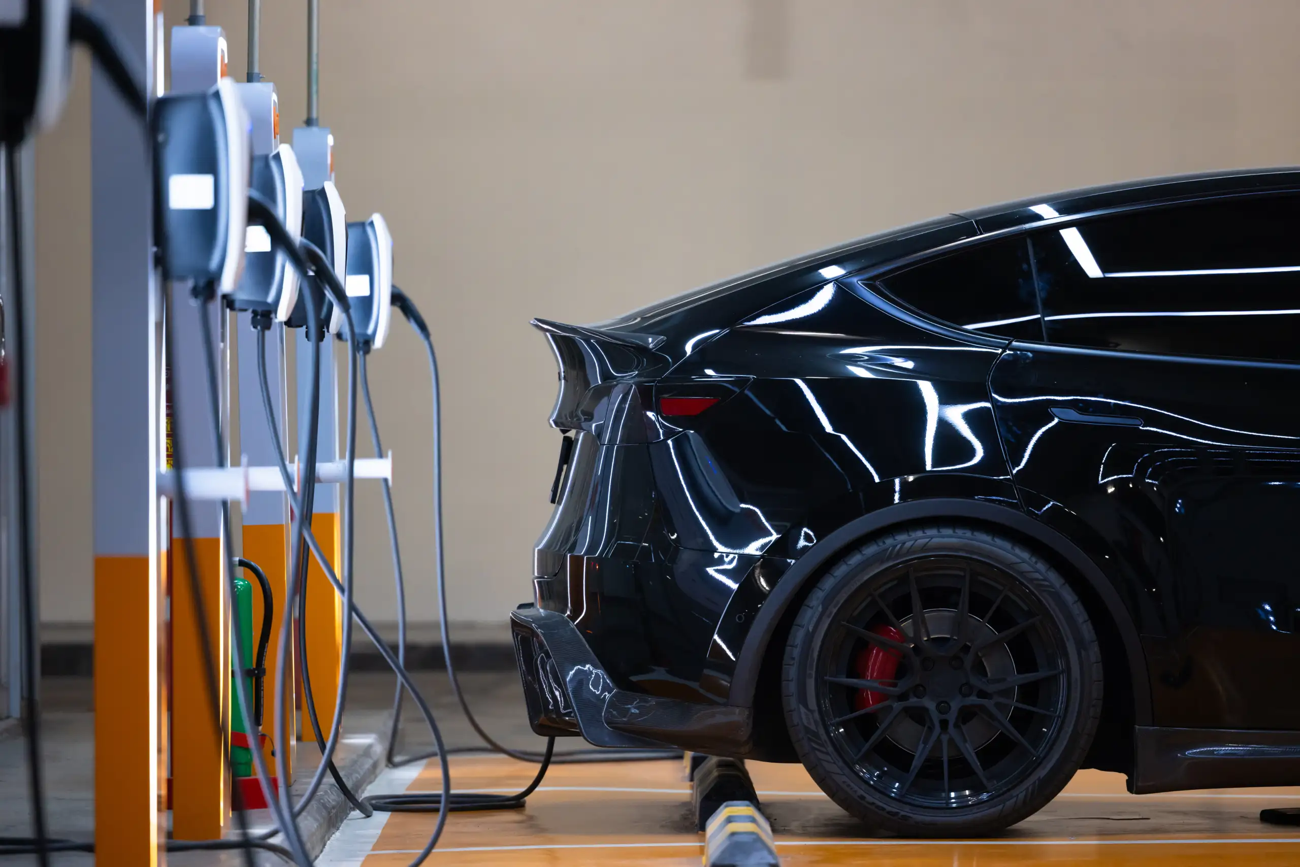 Coche eléctrico enchugado a estación de carga Coche eléctrico enchugado a estación de carga